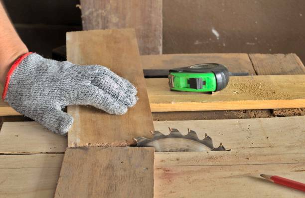 una maniglia di legno su un tavolo, una lama circolare sega nastro verde misurare matita rossa guanto grigio - circle blade wood dust foto e immagini stock