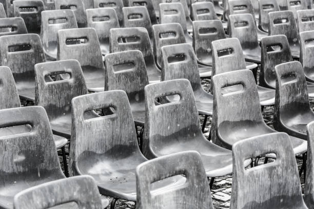 Stacked modern cafe chairs and tables of a closed sidewalk cafe during the second corona shutdown in autumn. (Germany)