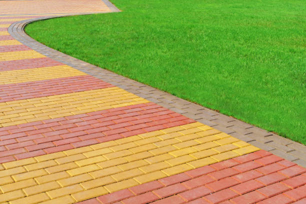 istock walkway made of paving slabs and green grass as a background, bright sunlight 1311107004