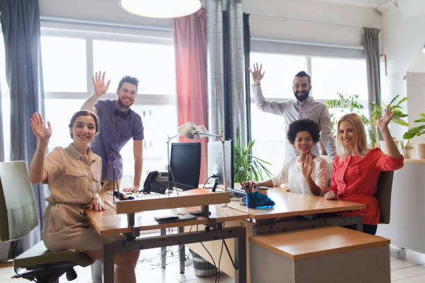 istock happy creative team waving hands in office 1311107698