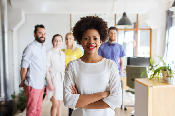 istock happy young woman over creative team in office 1311108021
