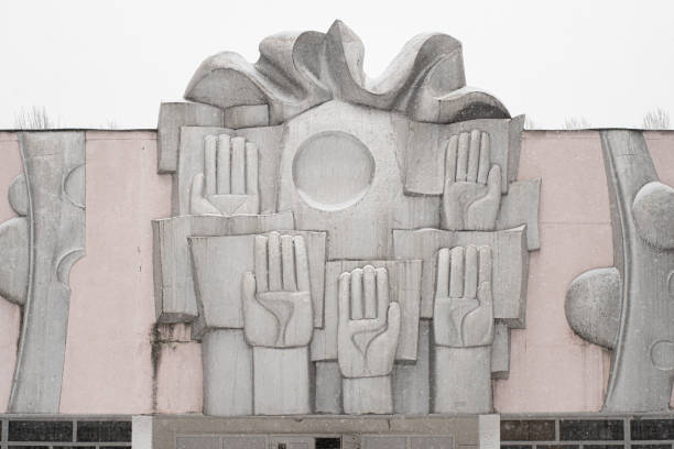 An old Soviet metal panel at the school, which shows the raised hands of students. Kyiv, Ukraine - Mar. 2021