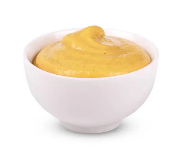 Photo of Mustard in white bowl isolated on white background