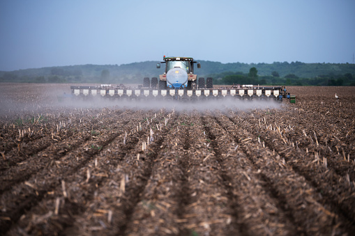 A shot of a tractor no-till sowing corn in a agricultural field.