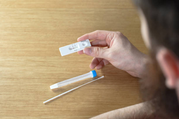 istock Young man holding a negative covid-19 self test at home, self test kit for Coronavirus top view with copy space 1311111091