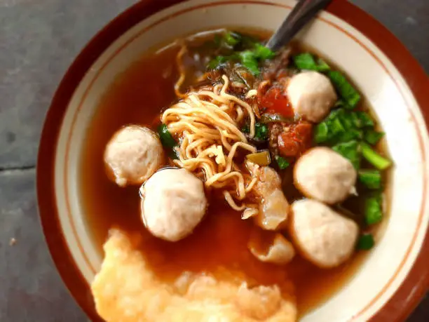 Mie Bakso is a popular Indonesian dumpling soup with meat balls, green leaf vegetables, noodles and crackers.