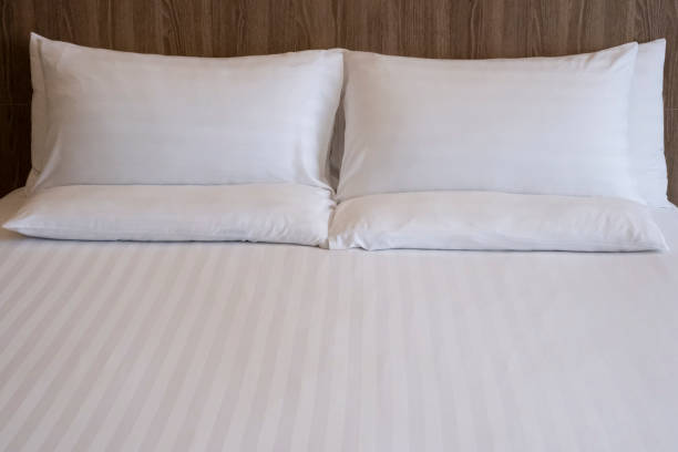 istock Clean white bed in hotel. White comfortable pillow on bed in bedroom. Bed sheets and pillows. Large bedroom, hotel room with white sheets, large pillows cushions. 1311113975