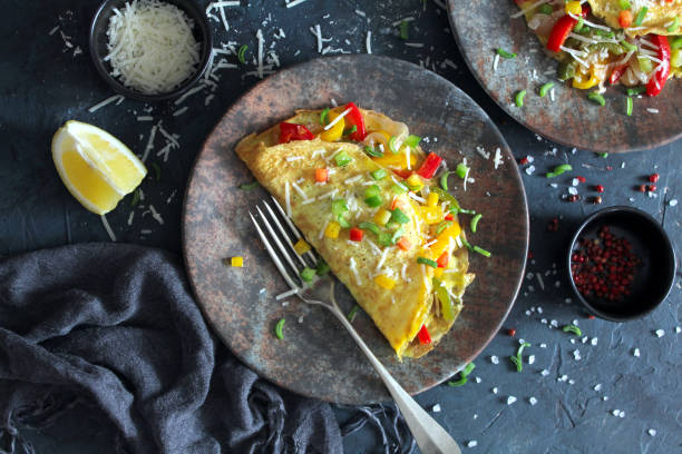 Healthy breakfast food: stuffed omelette with vegetables on dark background. stock photo