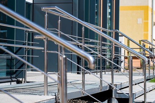 Silver chrome metal handrail on the background of stairs during the day