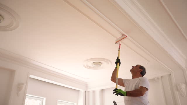 Male painter painting a ceiling