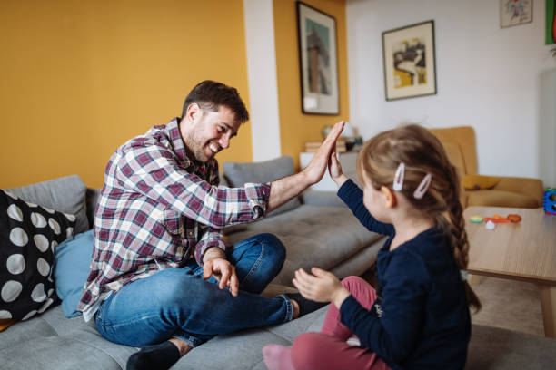 istock Father and daughter singing nursery rhymes and high five 1311117104