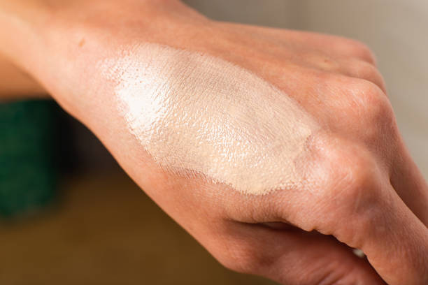 Swatch of tonal foundations on the woman hand closeup texture stock photo