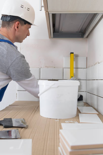 istock the tile installation wizard measures the correct laying of white tiles, using the yellow level 1311119371