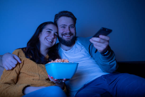 istock Pair eating popcorn and watching movie 1311119381