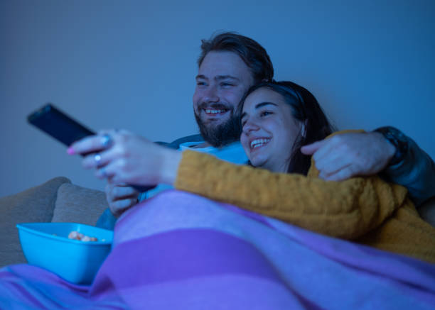 istock Happy pair smiling and watching movie 1311121169