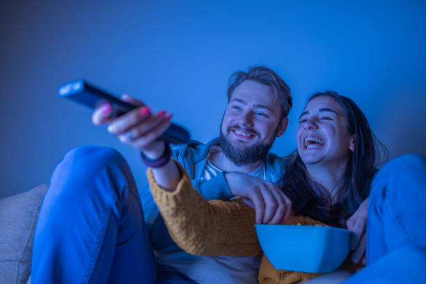 istock Young couple watching movie and smiling 1311121464