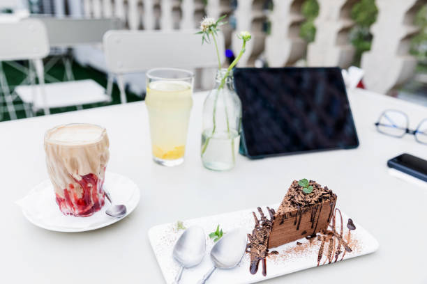 Digital tablet, cell phone ,drink on table in a cafe