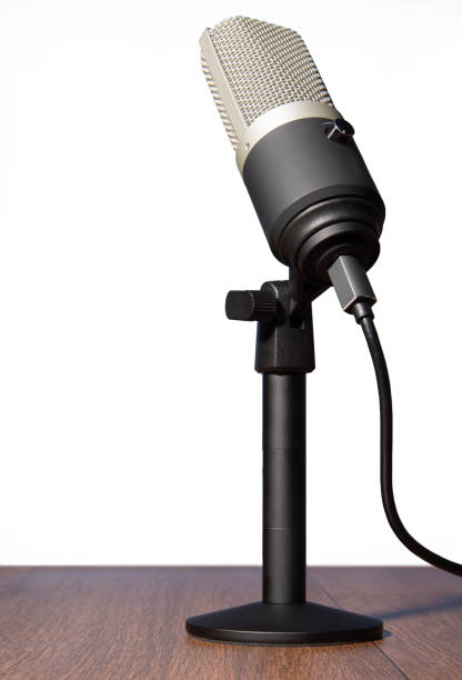 istock professional condenser microphone with pedestal isolated with white background on wood, selective focus. 1311124041