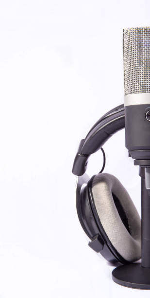 istock home work, professional condenser microphone and headphones on white background, high key portrait, selective focus. 1311124146