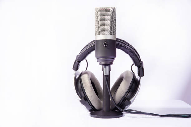 home work, professional condenser microphone and headphones on white background, high key portrait, selective focus.