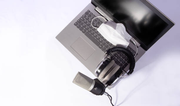 istock home work, professional condenser headset microphone, computer and mask against covid-19, white background, top view. 1311124358
