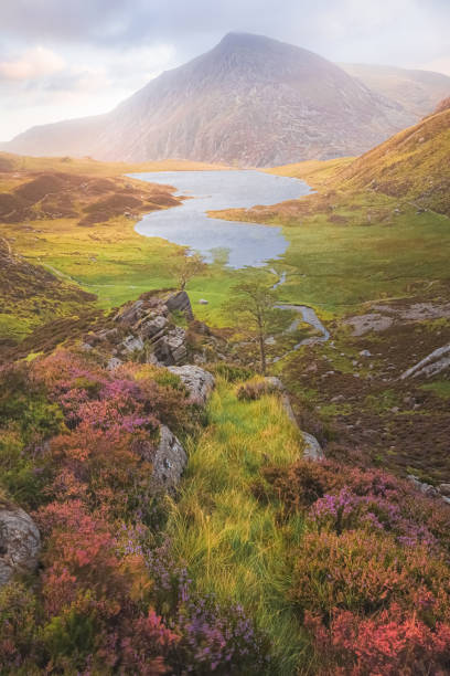 Dramatic, colourful landscape of Cwm Idwal in the Gyderau mountains of Snowdonia National Park in North Wales during sunset or sunrise.