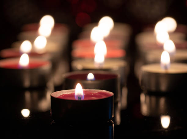 fondo con velas de luz de té brilla en la oscuridad. - tea light fotografías e imágenes de stock