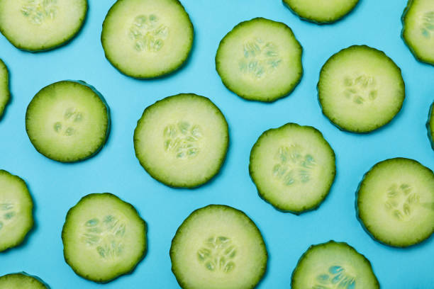 istock Fresh ripe cucumber slices on blue background 1311128300