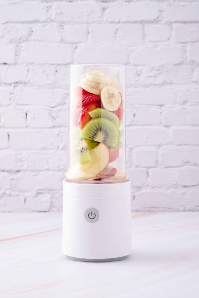 mixed fruit, apple, kiwi, banana and strawberry in portable blender ready to make smoothie - blender apple banana color image imagens e fotografias de stock