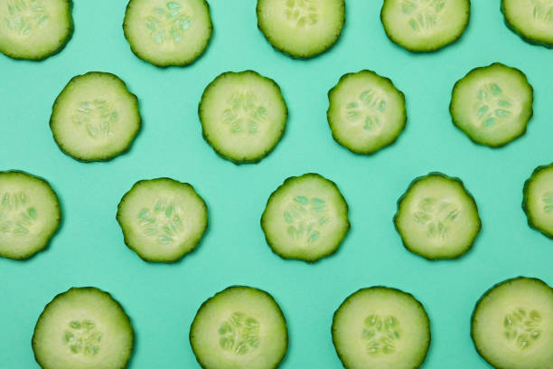 istock Fresh ripe cucumber slices on mint background 1311128645
