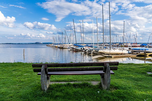 Mardorf, Lower Saxony, Germany - June 07, 2020: A bench at the Steinhuder Meer with the Marina and the spoil heap of the potash mine in the background