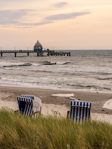 Zingst, Mecklenburg-Western Pomerania, Germany - June 13, 2020: Beach chairs on the beach and the sea-bridge in the background