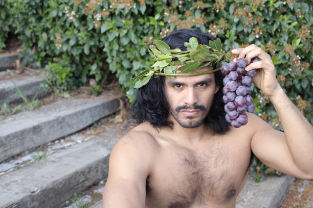 istock Attractive Mediterranean man with laurel crown holding grapes 1311131482