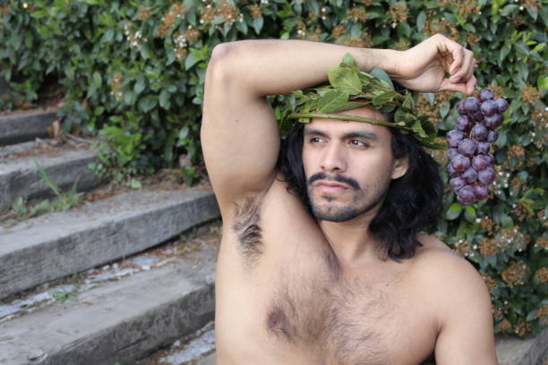 istock Attractive Mediterranean man with laurel crown holding grapes 1311132415