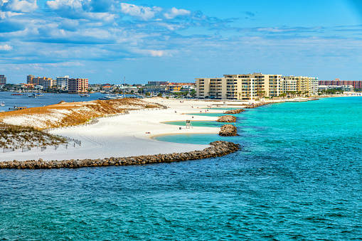 A beautiful white sand beach along Destin Harbor on the Gulf Coast of Florida on a warm spring day.