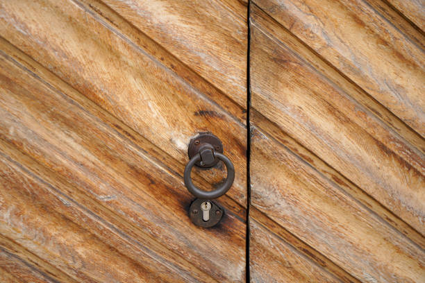 This is a door lock and door knocker on old doors photographed in daylight