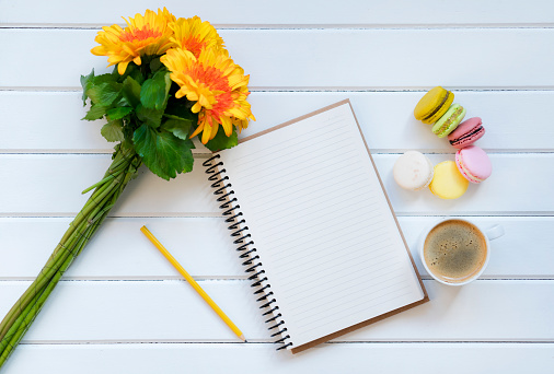 cup of coffee with notebook on wood