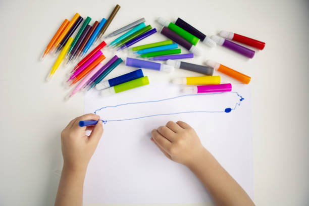 istock boy child sits at home at a table and draws with colored markers on a white sheet 1311138469