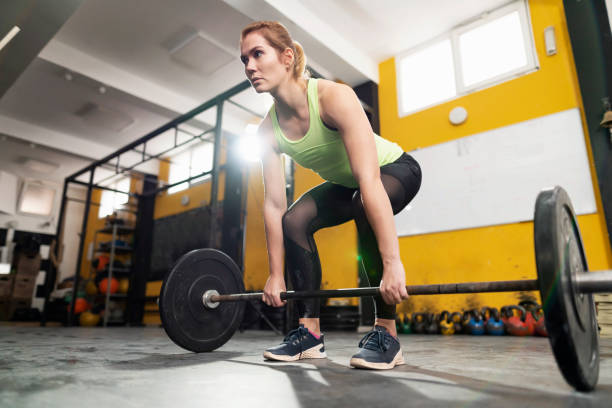 istock Young female athlete  squatting while lifting a barbell with weights in the gym 1311139765