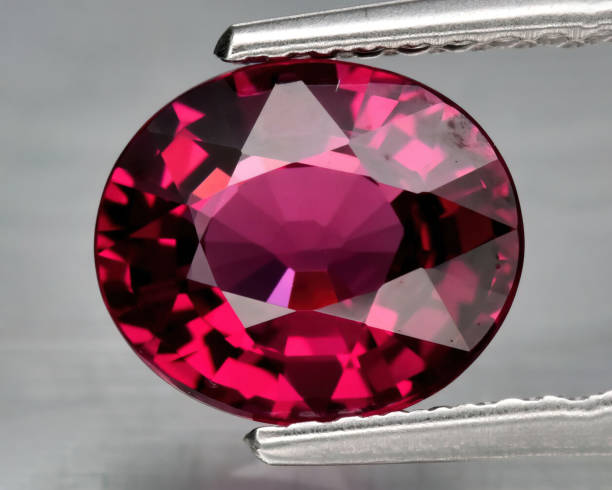 istock Natural gemstone rhodolite garnet on gray background 1311143820
