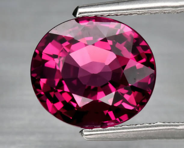 istock Natural gemstone rhodolite garnet on gray background 1311143830