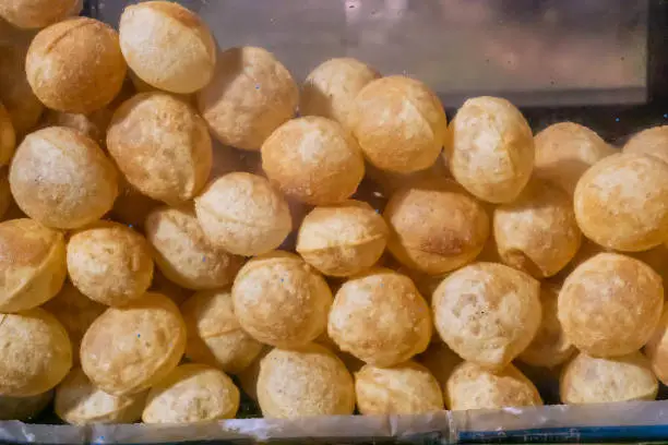 Panipuri or fuchka or gupchup or golgappa, a snack that is one of the most common street foods in India, Being sold behind covered glass at roadside in Howrah, West Bengal, India