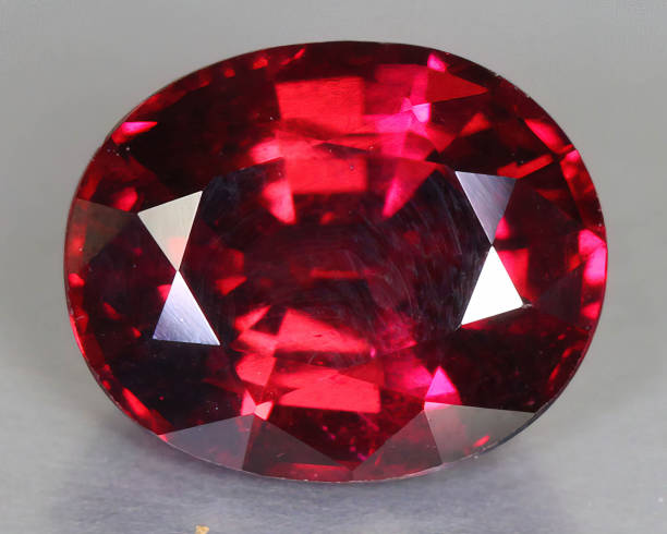 istock Natural gemstone rhodolite garnet on gray background 1311144967