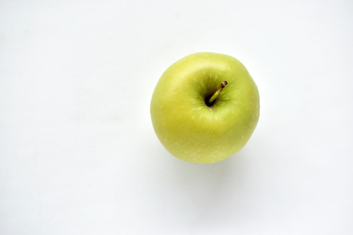A bright green apple on a white background
