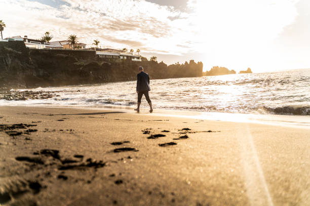 istock Business man walking on the beach at sunset light. Freedom. 1311146220