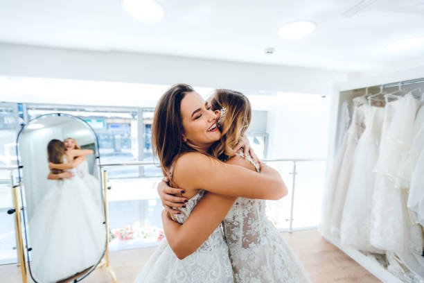 Two Brides embracing in bridal store