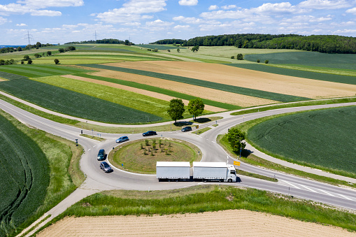 Cars and trucks driving on a traffic circle, aerial view.