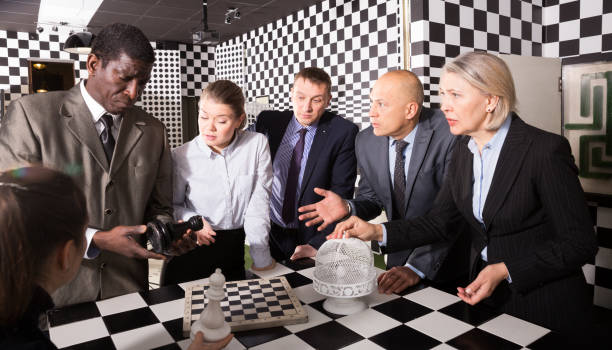 partnerzy biznesowi dyskutujący w szachowym escape roomie - chess board room business strategy zdjęcia i obrazy z banku zdjęć