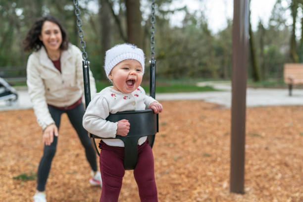 istock Laughing Baby On Swing At Park 1311149648