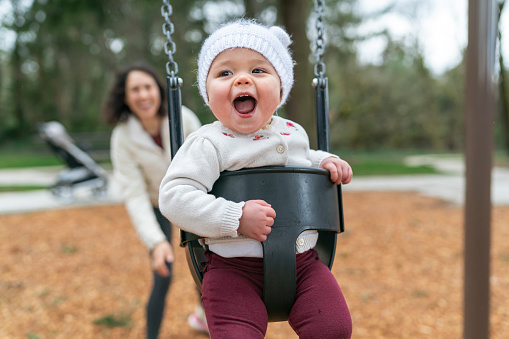 Laughing Baby At Park On Swing